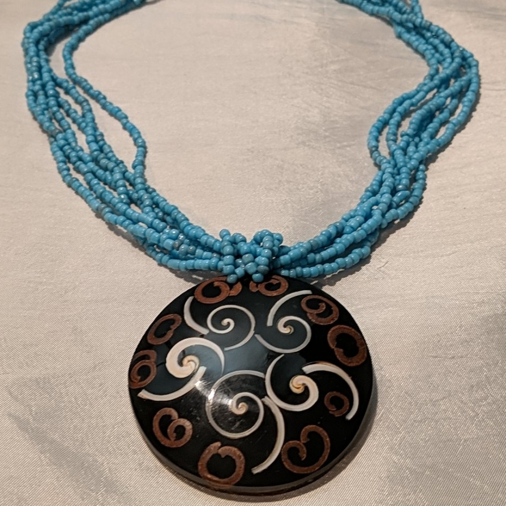 Beaded multi-strand necklace with brown pendant